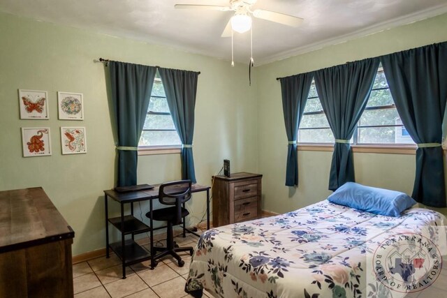 tiled bedroom featuring multiple windows and ceiling fan