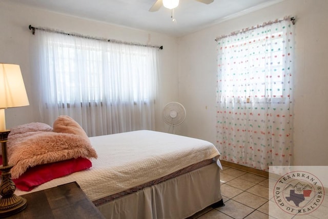 bedroom with multiple windows, light tile patterned floors, and ceiling fan