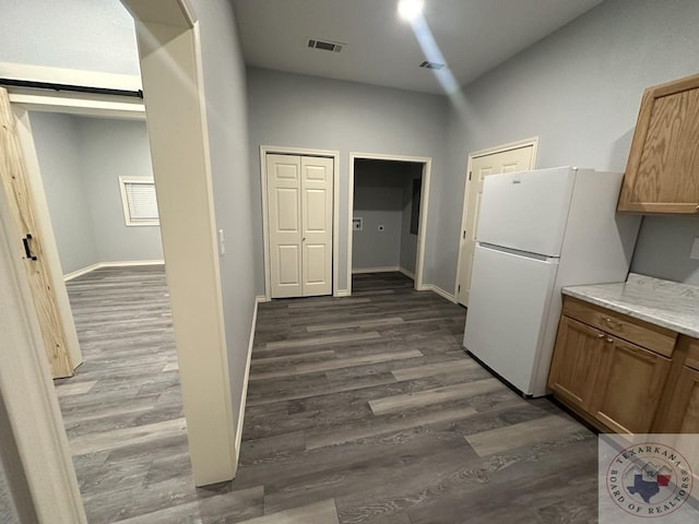 kitchen with white fridge, dark hardwood / wood-style floors, and a barn door