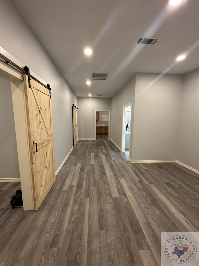 interior space with dark hardwood / wood-style floors and a barn door