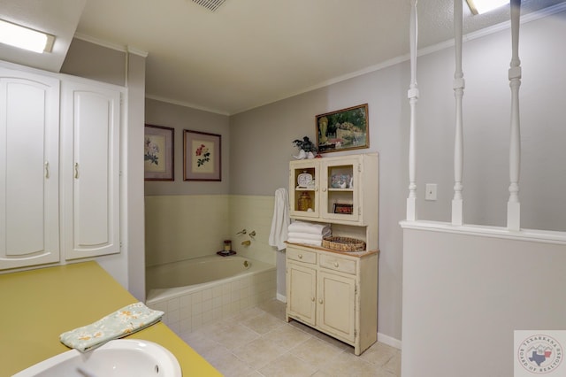 bathroom featuring crown molding, tile patterned flooring, a relaxing tiled tub, and vanity