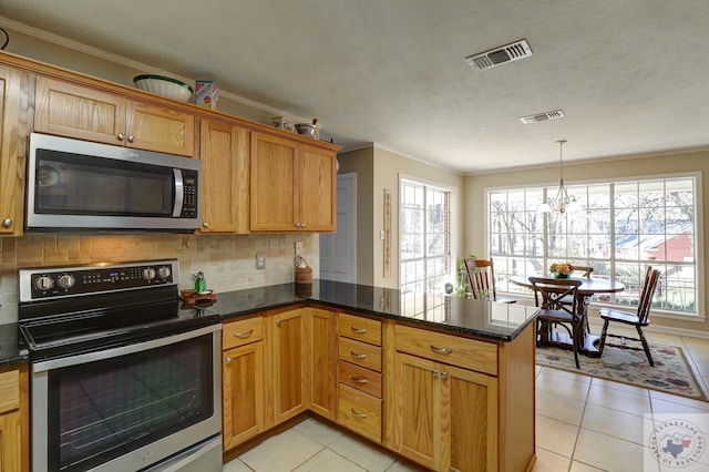 kitchen with stainless steel appliances, kitchen peninsula, light tile patterned floors, and a textured ceiling