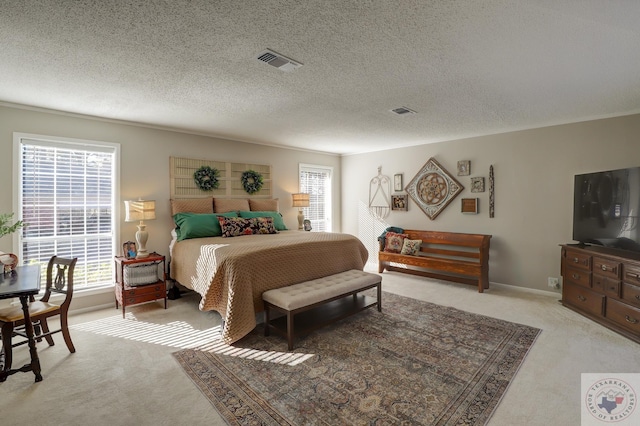 bedroom featuring light carpet and a textured ceiling