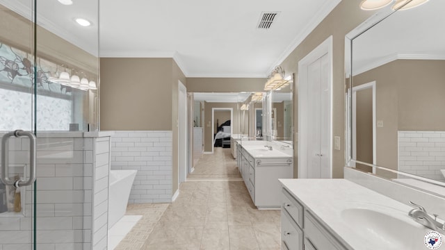 2 Spring Valley Ln, Texarkana, AR 71854 - ensuite bathroom featuring two vanities, a freestanding tub, crown molding, recessed lighting, and wainscoting