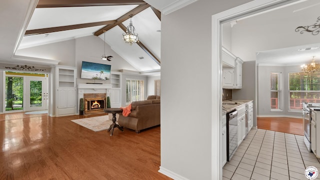 2 Spring Valley Ln, Texarkana, AR 71854 - kitchen with appliances with stainless steel finishes, a chandelier, white cabinetry, a fireplace with flush hearth, and healthy amount of natural light
