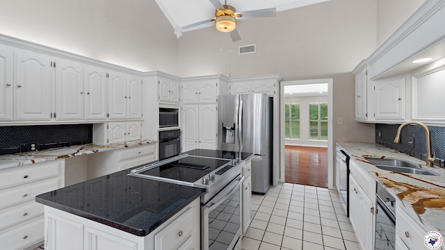 2 Spring Valley Ln, Texarkana, AR 71854 - kitchen featuring appliances with stainless steel finishes, high vaulted ceiling, a sink, light tile patterned flooring, and backsplash