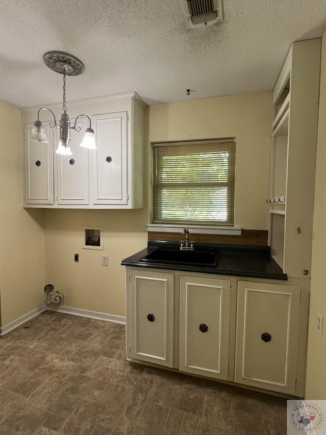 30 Broadmoor Dr, Texarkana, AR 71854 - laundry area with hookup for a washing machine, electric dryer hookup, a textured ceiling, baseboards, and cabinet space