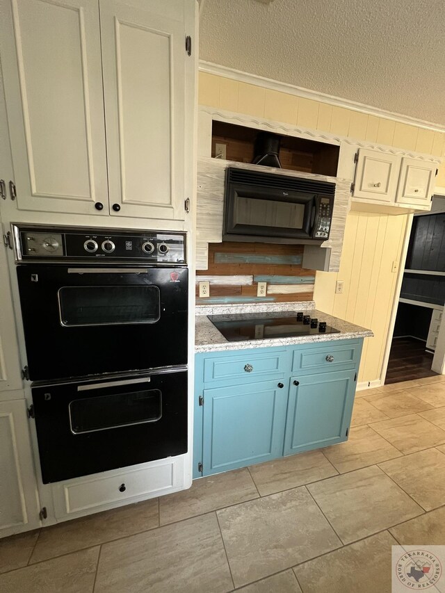 30 Broadmoor Dr, Texarkana, AR 71854 - kitchen featuring black appliances, blue cabinets, a textured ceiling, and light stone countertops