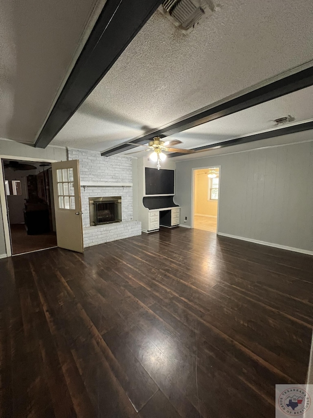 30 Broadmoor Dr, Texarkana, AR 71854 - unfurnished living room featuring hardwood / wood-style floors, beam ceiling, a textured ceiling, a brick fireplace, and baseboards