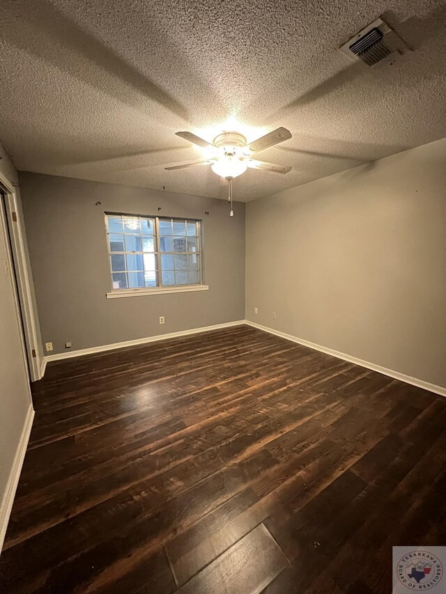 30 Broadmoor Dr, Texarkana, AR 71854 - unfurnished bedroom featuring dark wood-style flooring, baseboards, and a textured ceiling