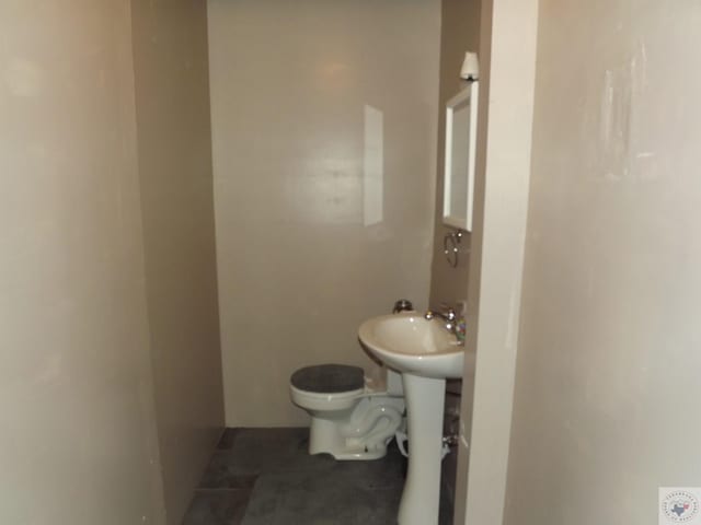 bathroom featuring toilet and tile patterned flooring