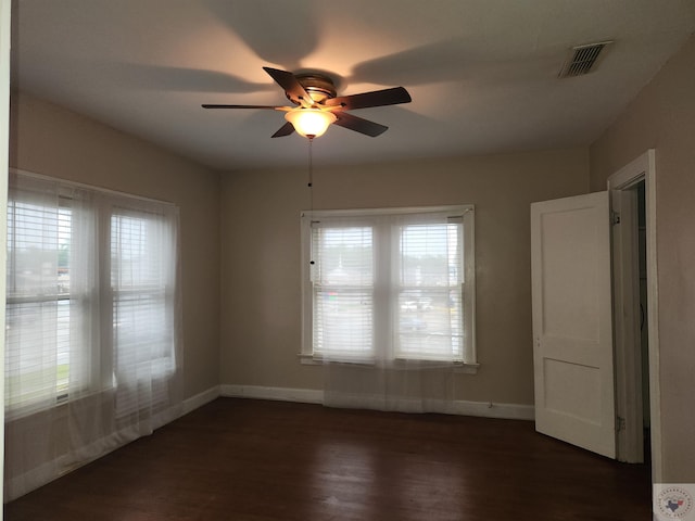 spare room with dark hardwood / wood-style floors and ceiling fan