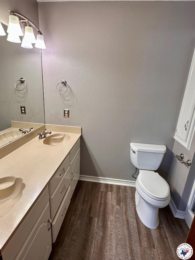 3119CLEARCREE Clear Crk, Texarkana, TX 75503 - bathroom featuring wood finished floors, toilet, double vanity, and baseboards