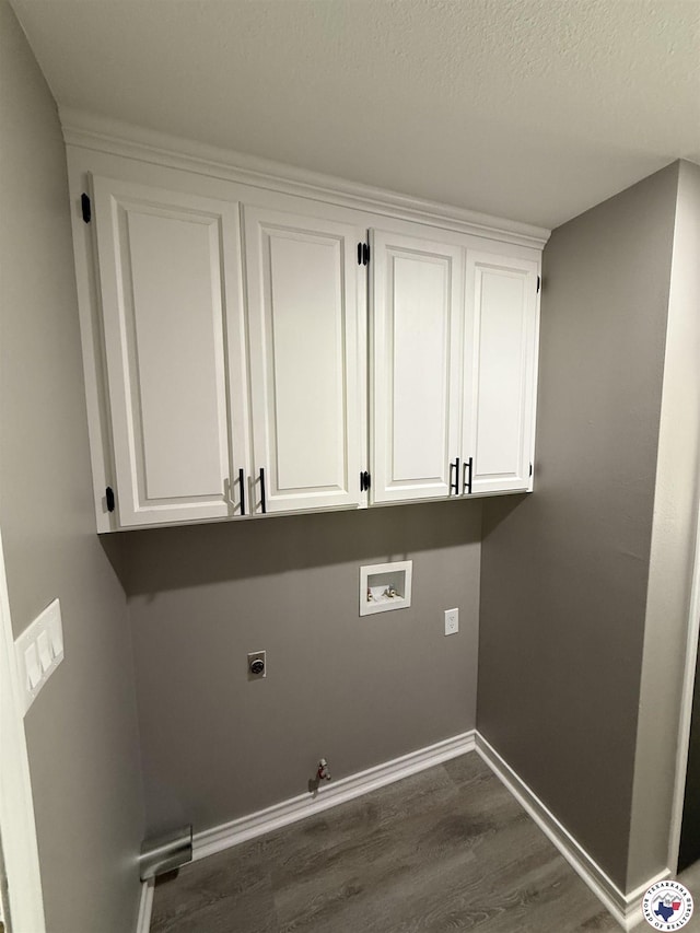 washroom with baseboards, gas dryer hookup, dark wood-type flooring, electric dryer hookup, and hookup for a washing machine