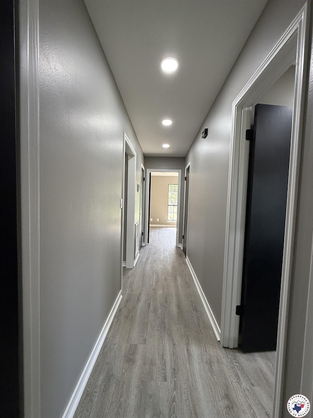 hall with baseboards, recessed lighting, and wood finished floors