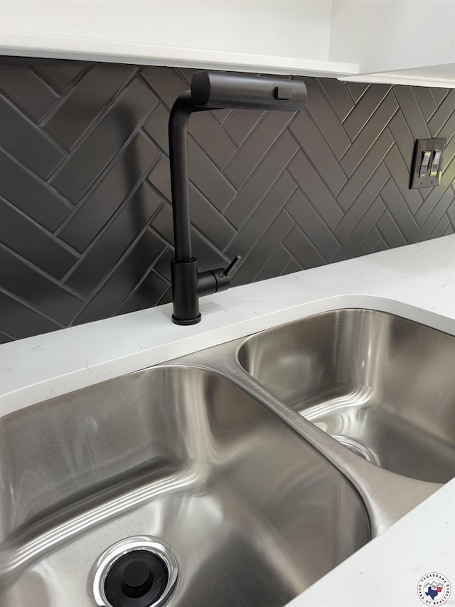 details featuring a sink and light stone counters