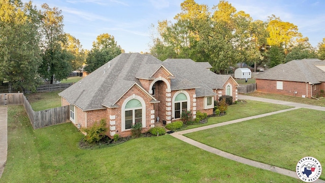 6404 N Park Rd, Texarkana, TX 75503 - view of front of house featuring fence, a shingled roof, a front yard, and brick siding
