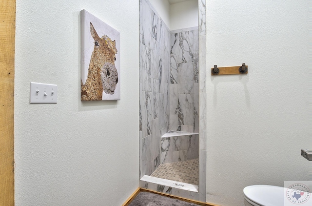 bathroom with tiled shower and toilet