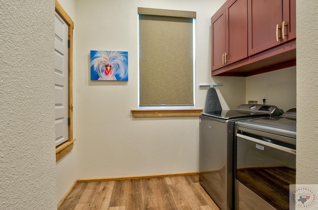 clothes washing area featuring light hardwood / wood-style floors, cabinets, and independent washer and dryer