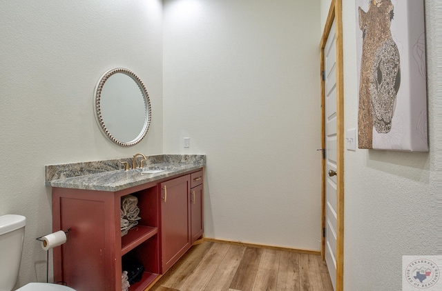 bathroom featuring hardwood / wood-style flooring, toilet, and vanity