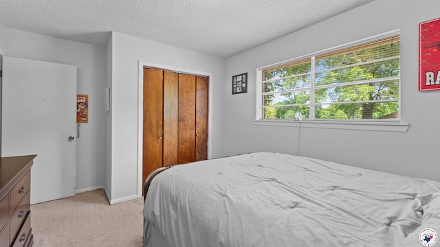 4133 Minden Ave, Texarkana, AR 71854 - bedroom with light carpet, a closet, a textured ceiling, and baseboards