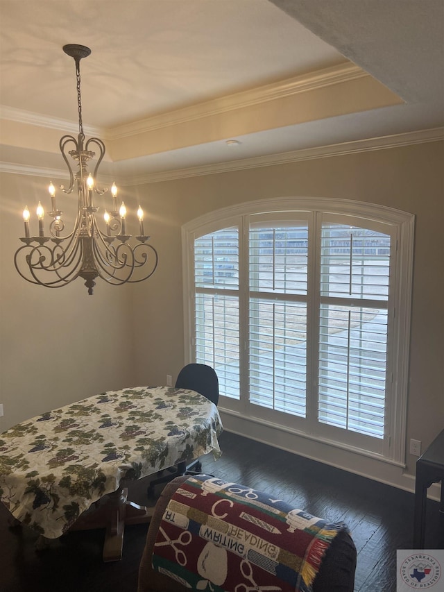 dining space featuring wood-type flooring, a tray ceiling, and crown molding