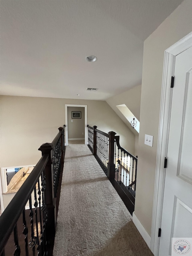 hall featuring lofted ceiling with skylight and carpet floors