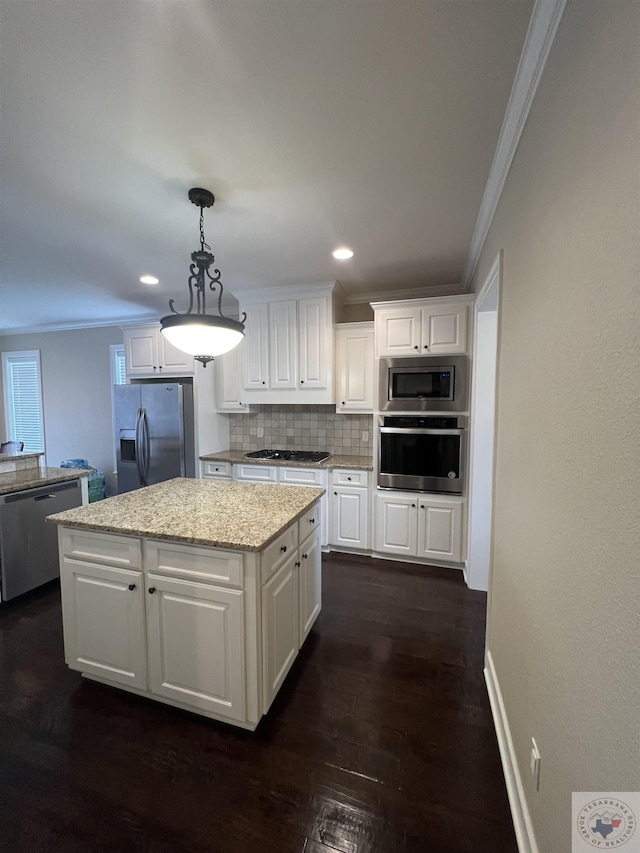 kitchen featuring white cabinets, a kitchen island, stainless steel appliances, backsplash, and hanging light fixtures