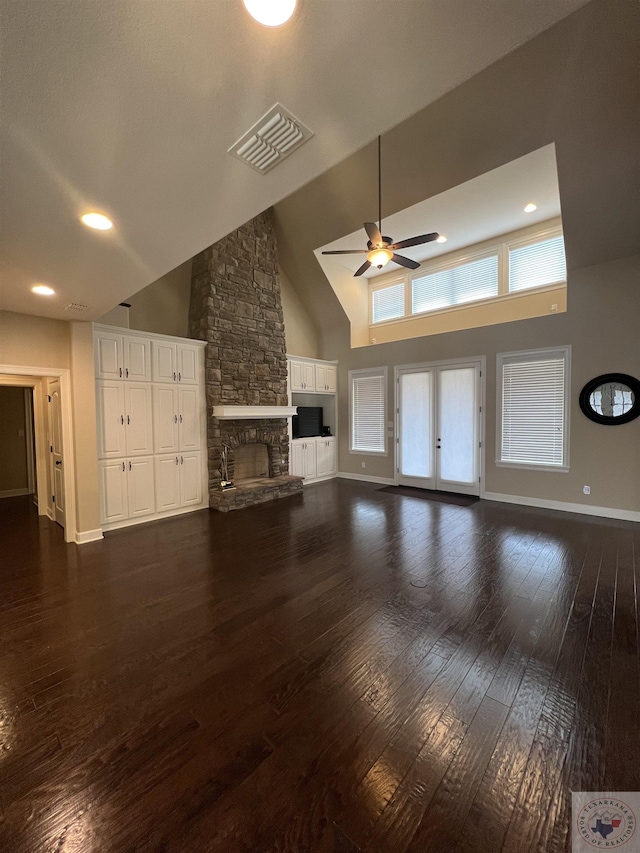 unfurnished living room with ceiling fan, high vaulted ceiling, dark wood-type flooring, and a fireplace