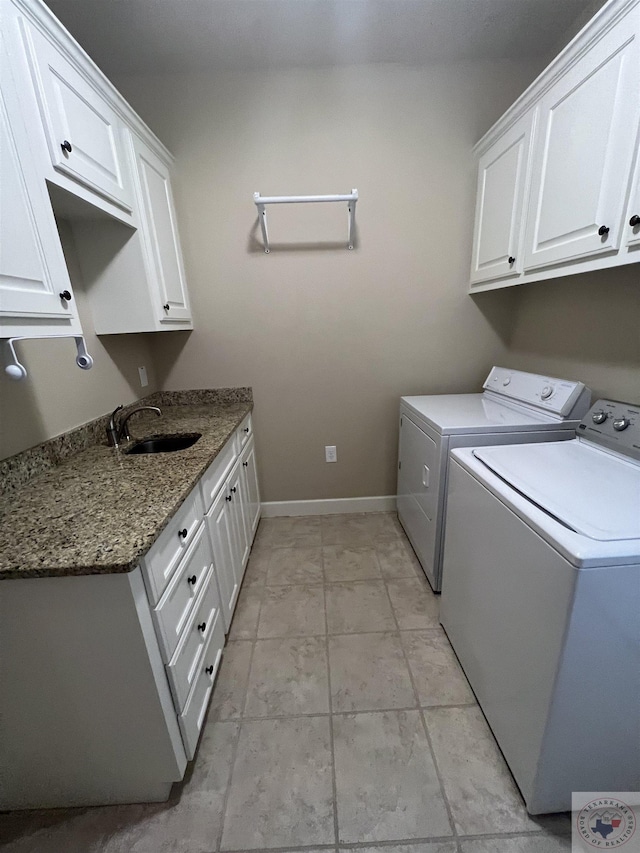 laundry area featuring sink, cabinets, light tile patterned floors, and washing machine and clothes dryer