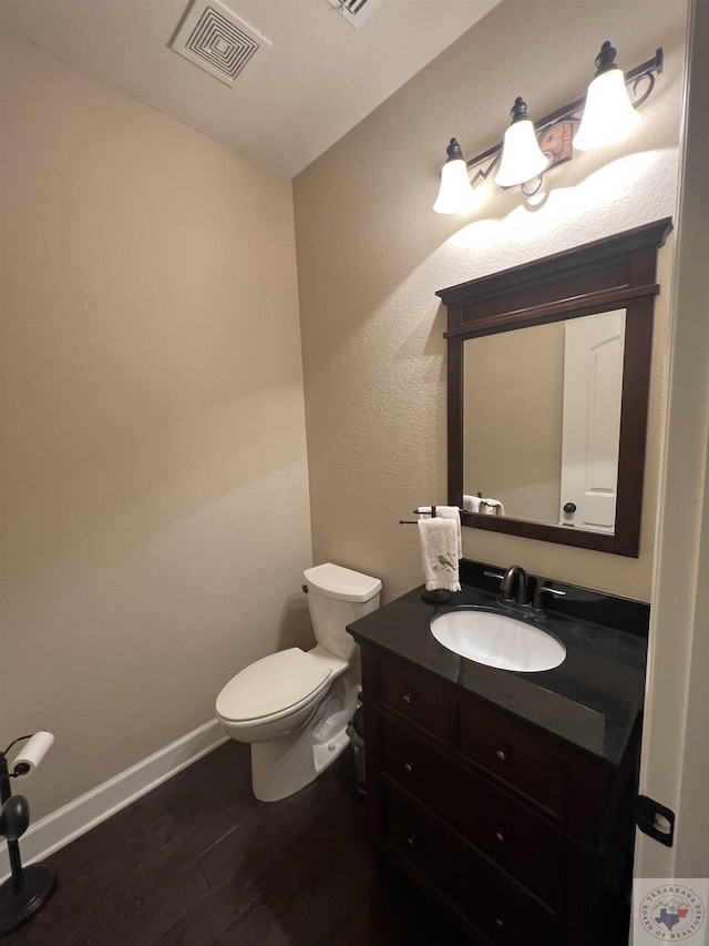 bathroom featuring wood-type flooring, toilet, and vanity