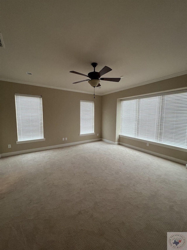 unfurnished room featuring ceiling fan, light colored carpet, and crown molding