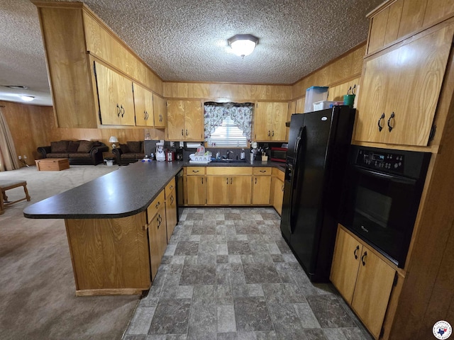 123 Texas Ln, New Boston, TX 75570 - kitchen featuring black appliances, a peninsula, a textured ceiling, dark countertops, and a sink