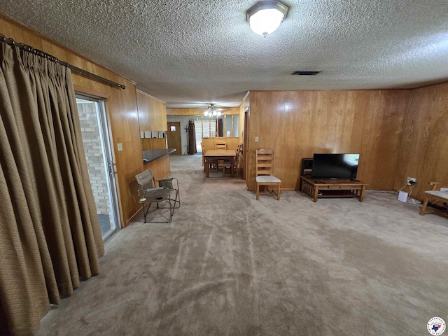 123 Texas Ln, New Boston, TX 75570 - sitting room featuring a textured ceiling, carpet flooring, wooden walls, and ceiling fan