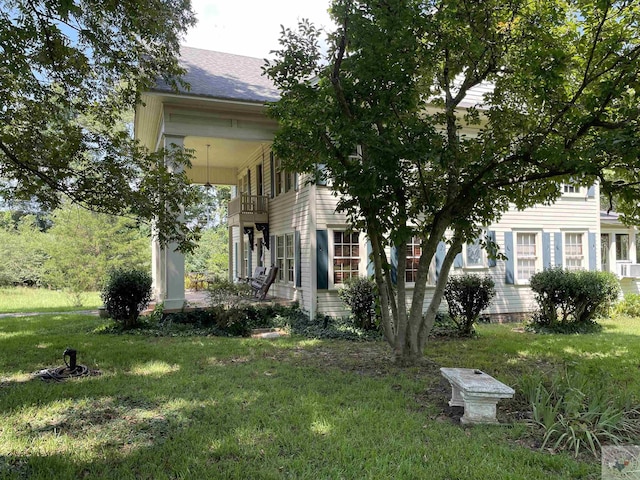 view of front of home featuring a front yard and a balcony