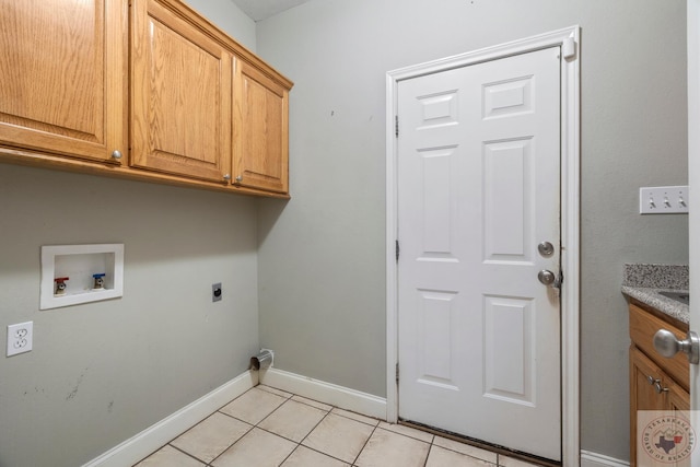 laundry room featuring electric dryer hookup, cabinets, washer hookup, and light tile patterned flooring