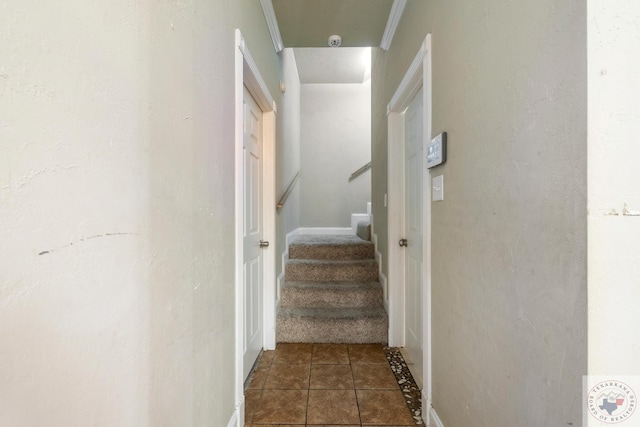 staircase with ornamental molding and tile patterned flooring