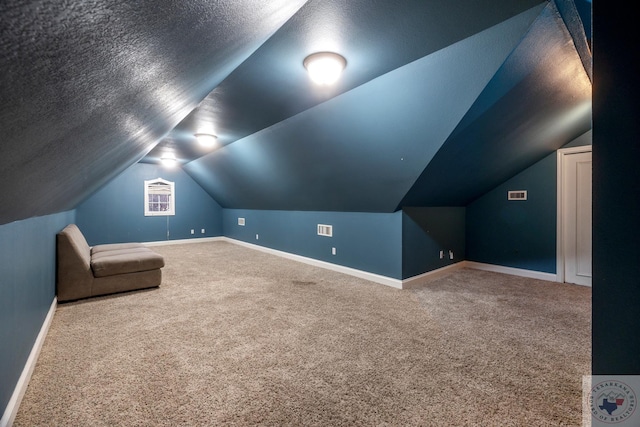 bonus room with a textured ceiling, carpet flooring, and vaulted ceiling