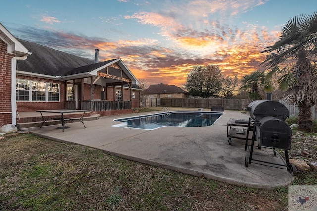 pool at dusk with a patio