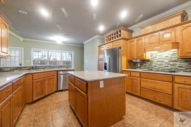 kitchen with appliances with stainless steel finishes, a kitchen island, backsplash, ornamental molding, and light tile patterned floors