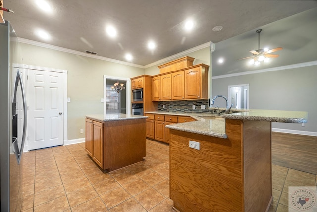 kitchen with kitchen peninsula, ornamental molding, stainless steel appliances, and a kitchen island