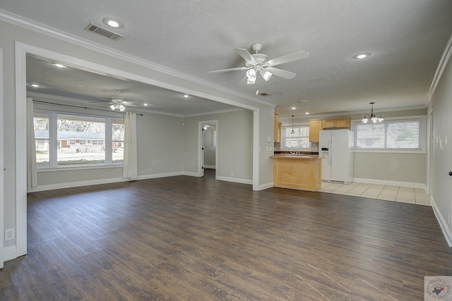 unfurnished living room with ornamental molding, wood finished floors, and visible vents