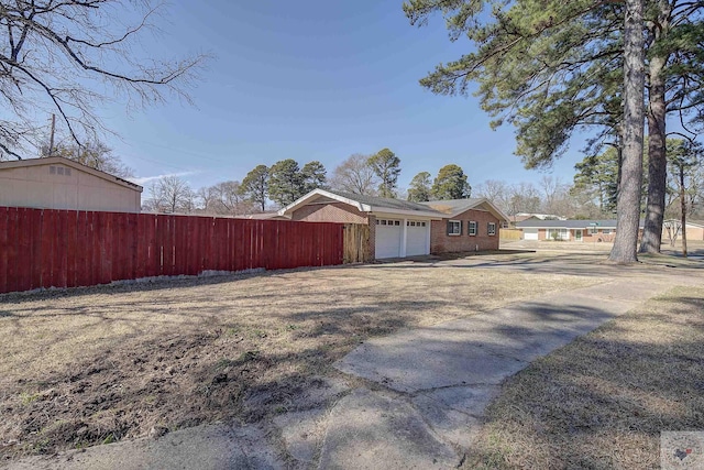 view of property exterior with an attached garage, driveway, and brick siding