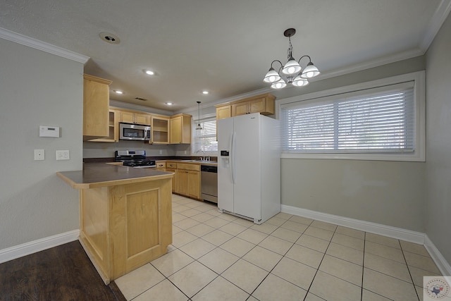 kitchen featuring stainless steel appliances, crown molding, a sink, and a peninsula