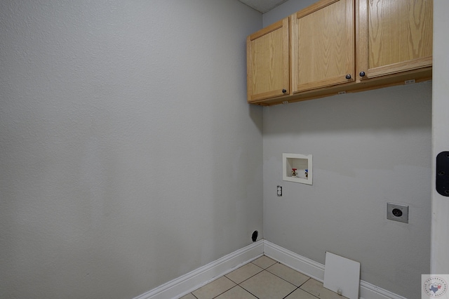 washroom with cabinet space, light tile patterned floors, baseboards, hookup for a washing machine, and electric dryer hookup