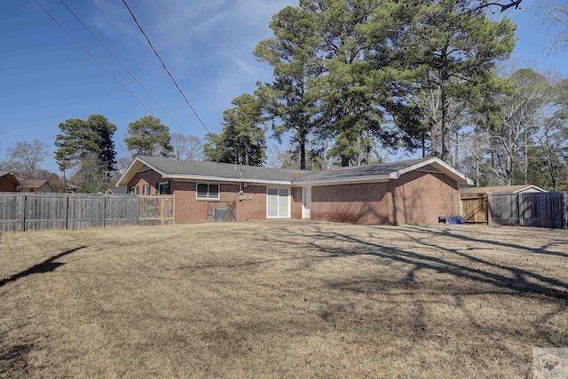 rear view of house with brick siding and fence