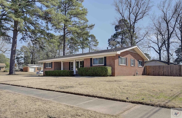 single story home featuring a front yard, fence, and brick siding