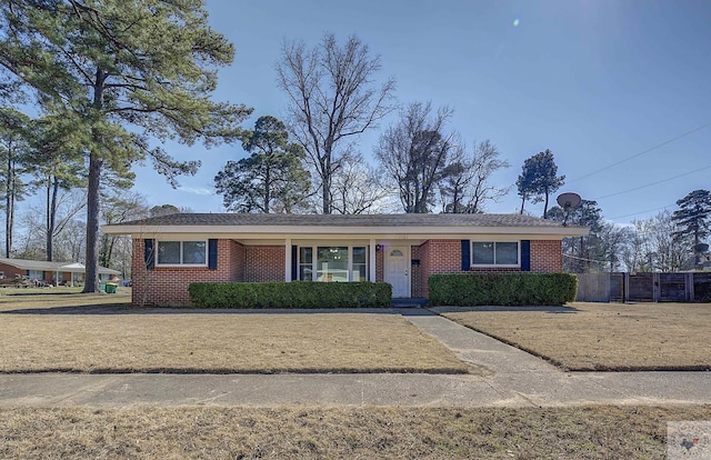 ranch-style home with brick siding, a front yard, and fence