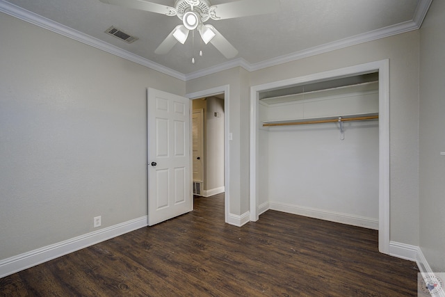 unfurnished bedroom with a closet, visible vents, dark wood-type flooring, ornamental molding, and baseboards