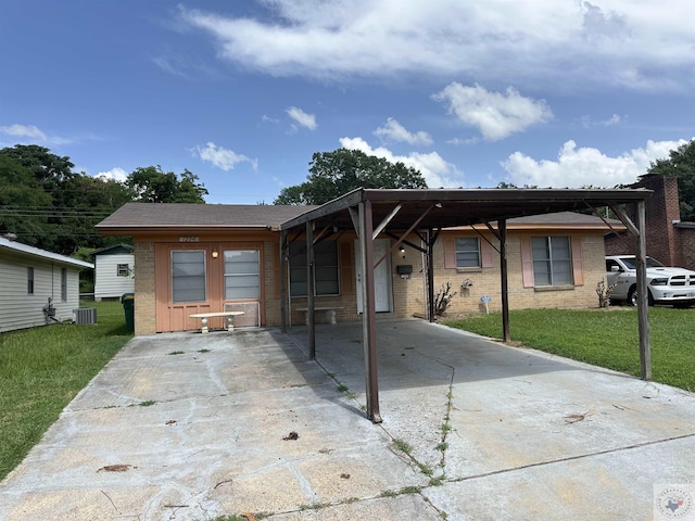 ranch-style house with central air condition unit, a carport, and a front lawn